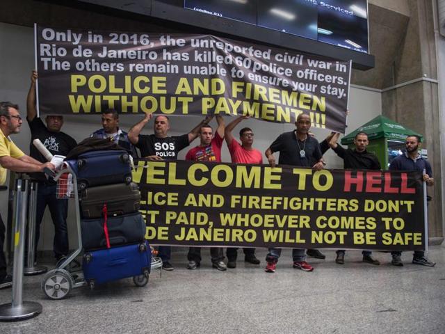 Police officers welcome passengers with a banner reading "Welcome to Hell" and other slogans as they protest against the government for delay in their salary payments at Tom Jobim International Airport in Rio de Janeiro, Brazil. (AFP Photo) Police officers welcome passengers with a banner reading "Welcome to Hell" and other slogans as they protest against the government for delay in their salary payments at Tom Jobim International Airport in Rio de Janeiro, Brazil. (AFP Photo)