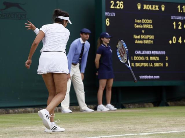 Sania Mirza throws her racquet in frustration during her mixed doubles match against Neal Skupski and Anna Smith of Britain. Mirza and partner Ivan Dodig lost in three sets despite holding match points. (AP)