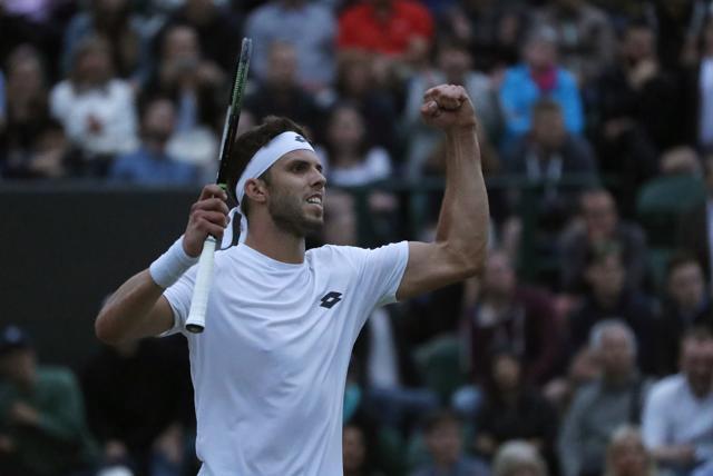 Jiri Vesely celebrates after winning the fourth set in fading light. (AP)