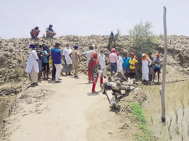 Farmers near the embankment built by the army during the Kargil War to strengthen defences at Khemkaran district in Tarn Taran. (HT Photo) Farmers near the embankment built by the army during the Kargil War to strengthen defences at Khemkaran district in Tarn Taran. (HT Photo)