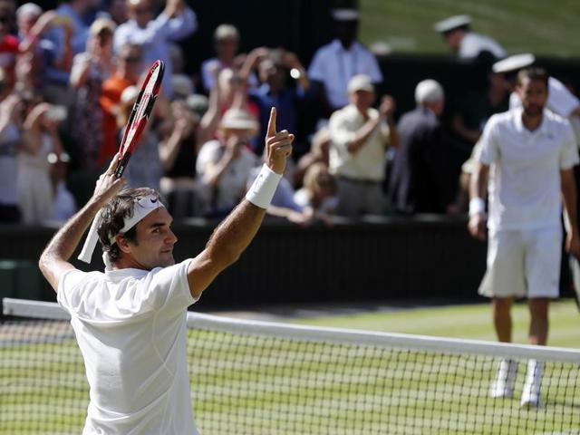 Federer celebrates his win as Cilic walks to the net to congratulate him. (AP)