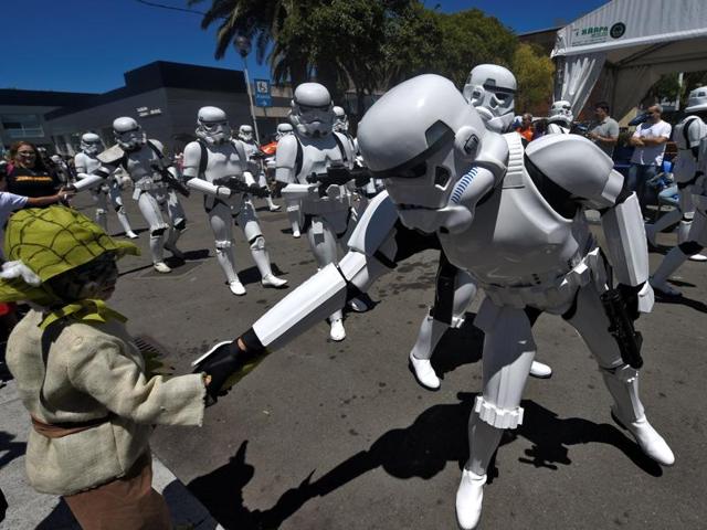 Persons wearing Star Wars costumes shakes hand with a little fan during the parade. (REUTERS) Persons wearing Star Wars costumes shakes hand with a little fan during the parade. (REUTERS)
