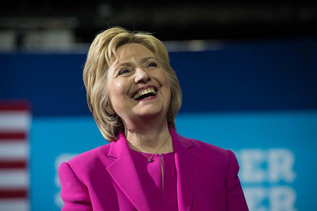 US Democratic presidential candidate Hillary Clinton laughs as President Barack Obama speaks at a campaign event for in Charlotte, North Carolina, on July 5, 2016. US President Barack Obama threw his full weight behind Hillary Clinton's bid to succeed him, extolling the experience and fighting spirit of his former secretary of state at their first joint campaign appearance. "I'm here today because I believe in Hillary Clinton," Obama told the rally in Charlotte, North Carolina. "There has never been any man or woman more qualified for this office." / AFP PHOTO / NICHOLAS KAMM (AFP) US Democratic presidential candidate Hillary Clinton laughs as President Barack Obama speaks at a campaign event for in Charlotte, North Carolina, on July 5, 2016. US President Barack Obama threw his full weight behind Hillary Clinton's bid to succeed him, extolling the experience and fighting spirit of his former secretary of state at their first joint campaign appearance. "I'm here today because I believe in Hillary Clinton," Obama told the rally in Charlotte, North Carolina. "There has never been any man or woman more qualified for this office." / AFP PHOTO / NICHOLAS KAMM (AFP)