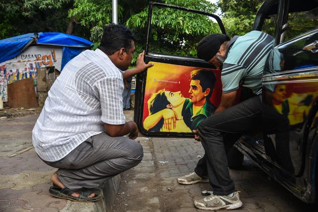 The team of Taxi Fabric pasting posters on to the interiors of a taxi (Photo: taxi fabric) The team of Taxi Fabric pasting posters on to the interiors of a taxi (Photo: taxi fabric)
