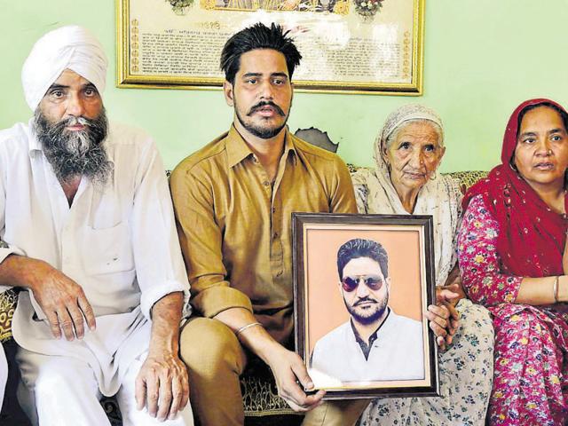 Family members of deceased Mukhjit Singh Mukha with his photograph at Verka village in Amritsar on Thursday.(Gurpreet Singh/HT Photo)