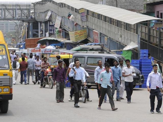 Both sides of the road are occupied by encroachers selling fruits, vegetables, clothes and household articles. Some have also extended their shops and display their items on the road to attract commuters and workers. (Abhinav Saha/HT Photo) Both sides of the road are occupied by encroachers selling fruits, vegetables, clothes and household articles. Some have also extended their shops and display their items on the road to attract commuters and workers. (Abhinav Saha/HT Photo)