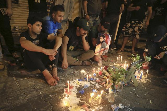 People light candles at the scene of Sunday's truck bombing in the Karada neighborhood, Baghdad, Iraq, Thursday. Protests and anger over the security situation in Iraq mounted Thursday at the site of the massive truck bombing by the Islamic State group earlier this week in Baghdad that killed scores as the death toll continued to rise and a separate attack north of Baghdad killed dozens more. (AP)