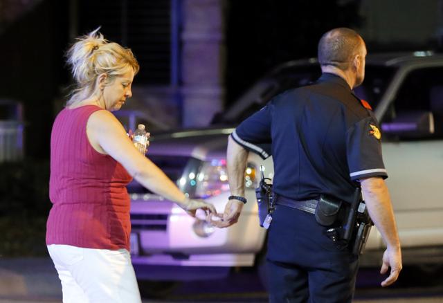 An unidentified woman and a law enforcement officer reach for each other's hand as they walk out of the Baylor University Medical Center emergency reception area in Dallas. (AP) An unidentified woman and a law enforcement officer reach for each other's hand as they walk out of the Baylor University Medical Center emergency reception area in Dallas. (AP)