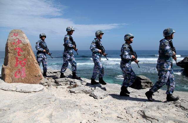 Soldiers of China's People's Liberation Army (PLA) Navy patrol at Woody Island, in the Paracel Archipelago, which is known in China as the Xisha Islands, January 29. The words on the rock read, "Xisha Old Dragon". Old Dragon is the local name of a pile of rocks near Woody Island. (REUTERS) Soldiers of China's People's Liberation Army (PLA) Navy patrol at Woody Island, in the Paracel Archipelago, which is known in China as the Xisha Islands, January 29. The words on the rock read, "Xisha Old Dragon". Old Dragon is the local name of a pile of rocks near Woody Island. (REUTERS)