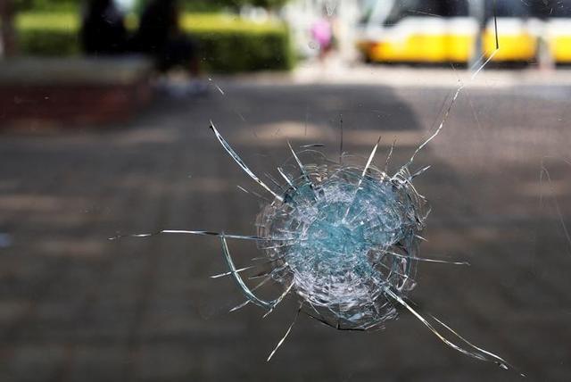 Broken glass from a bullet hole is seen at a bus stop near the shooting scene in Dallas. (Reuters)