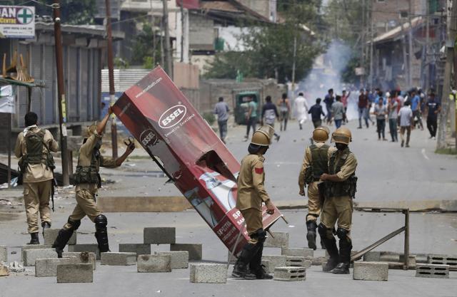 Policemen remove a roadblock set up by protesters during a protest in Srinagar,J-K, Saturday, July 9, 2016. (AP) Policemen remove a roadblock set up by protesters during a protest in Srinagar,J-K, Saturday, July 9, 2016. (AP)