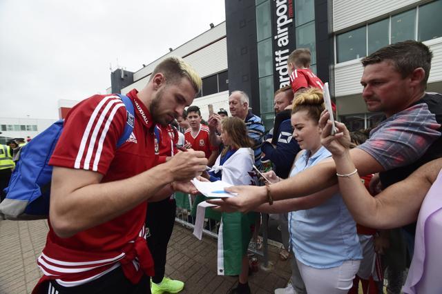 Wales' Aaron Ramsey signs autographs for fans as he arrives at Cardiff airport. (Reuters Photo) Wales' Aaron Ramsey signs autographs for fans as he arrives at Cardiff airport. (Reuters Photo)