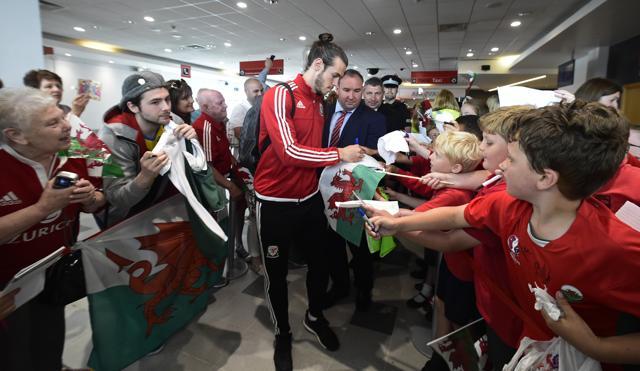 Wales' Gareth Bale signs autographs as he arrives at Cardiff airport. (Reuters Photo) Wales' Gareth Bale signs autographs as he arrives at Cardiff airport. (Reuters Photo)