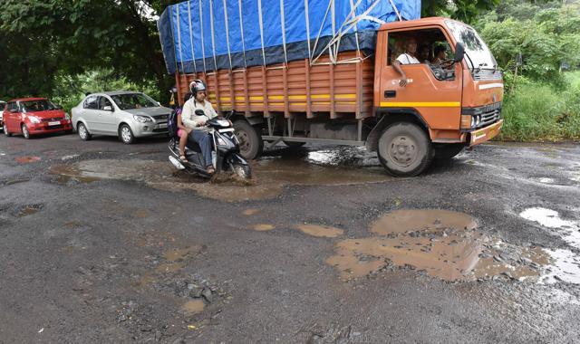 Motorists drive through the pothole-ridden Aarey road in Goregaon on Saturday. (Pratham Gokhale/ Hindustan Times)