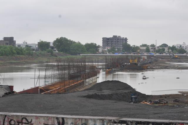 A 12-foot-wide wall being built on the Pipliyahana reservoir to divide the water body into two parts. The area on right side of the wall is being used for construction of modern district court complex.(Shankar Mourya/HT photo)