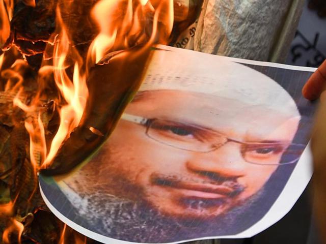 Delhi Pradesh Shiv Sena members protesting and burning effigy of Zakir Naik at Jantar Mantar in New Delhi on Saturday. The Islamic preacher has been at the centre of a major controversy since the Dhaka café attack. (Sonu Mehta /HT photo) Delhi Pradesh Shiv Sena members protesting and burning effigy of Zakir Naik at Jantar Mantar in New Delhi on Saturday. The Islamic preacher has been at the centre of a major controversy since the Dhaka café attack. (Sonu Mehta /HT photo)