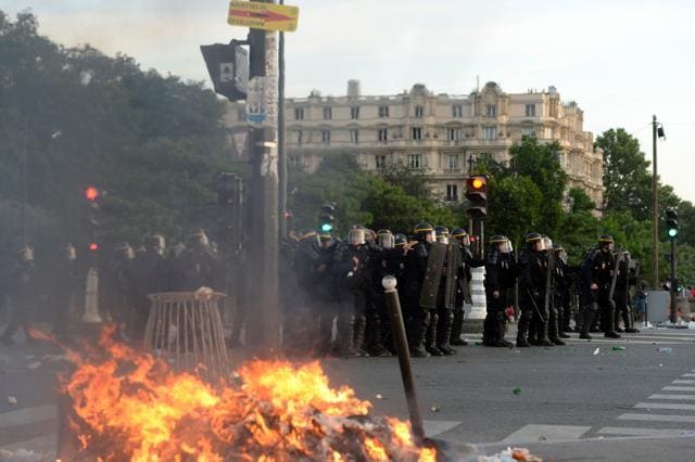French riot policemen stand near a fire during clashes prior to the Euro 2016 final football match between Portugal and France. (AFP PHOTO) French riot policemen stand near a fire during clashes prior to the Euro 2016 final football match between Portugal and France. (AFP PHOTO)