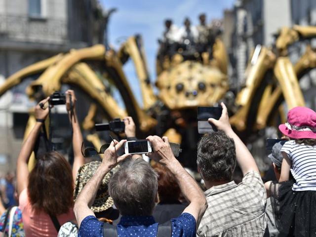 People take pictures of Kumo, a mechanical spider made of wood and steel by Les Machines de L'Ile (Machines of the Isle of Nantes) factory during the public presentation for the first time in the streets of Nantes. (AFP) People take pictures of Kumo, a mechanical spider made of wood and steel by Les Machines de L'Ile (Machines of the Isle of Nantes) factory during the public presentation for the first time in the streets of Nantes. (AFP)