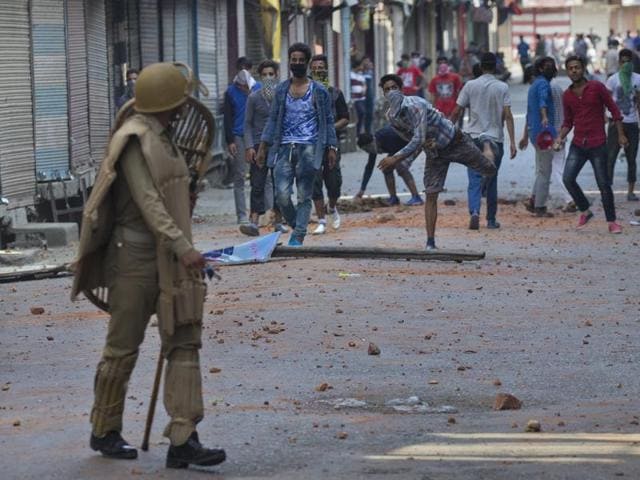 Protesters throw bricks and stones at policemen in Srinagar, Monday. Authorities were struggling Monday to contain protests which began after several people were killed in weekend demonstrations.(AP)