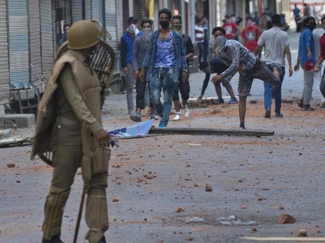 Protesters throw stones at policemen in Srinagar. Security forces were trying to contain protests by Kashmiris angry after several people were killed in weekend demonstrations, as youths defied a curfew to rally in the streets against the killing of militant Burhan Wani.(AP Photo)