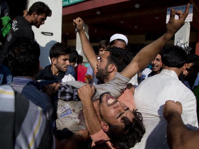 A Kashmiri man who was injured in clashes with security forces is helped out of an ambulance for treatment outside a hospital in Srinagar. (AP) A Kashmiri man who was injured in clashes with security forces is helped out of an ambulance for treatment outside a hospital in Srinagar. (AP)