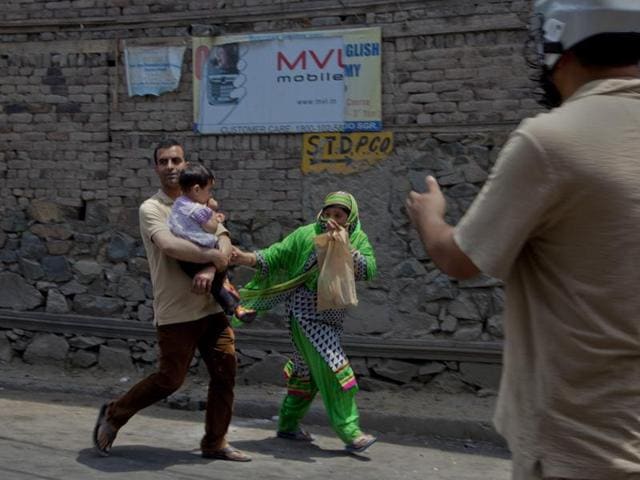 A family runs for cover as protesters clash with security forces in Srinagar. Clashes between troops and protesters continued despite a curfew imposed in the region. (AP) A family runs for cover as protesters clash with security forces in Srinagar. Clashes between troops and protesters continued despite a curfew imposed in the region. (AP)
