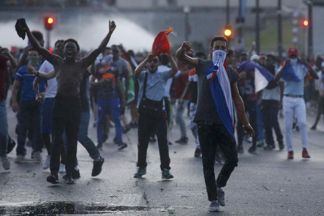 Youths taunt French riot police during clashes near the Paris fan zone. (REUTERS)
