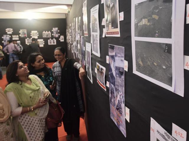 People attend a photo exhibition showcasing the plight of roads riddled with potholes in Mumbai. (Arijit Sen/HT Photo) People attend a photo exhibition showcasing the plight of roads riddled with potholes in Mumbai. (Arijit Sen/HT Photo)