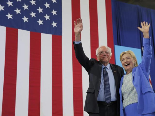 Democratic US presidential candidates Hillary Clinton and Bernie Sanders stand together during a campaign rally where Sanders endorsed Clinton in Portsmouth, New Hampshire, on Tuesday. (Reuters)