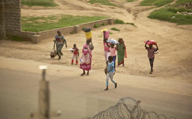 In this photo taken Saturday, July 9, 2016, people walk with their belongings in the capital Juba, South Sudan. (AP)