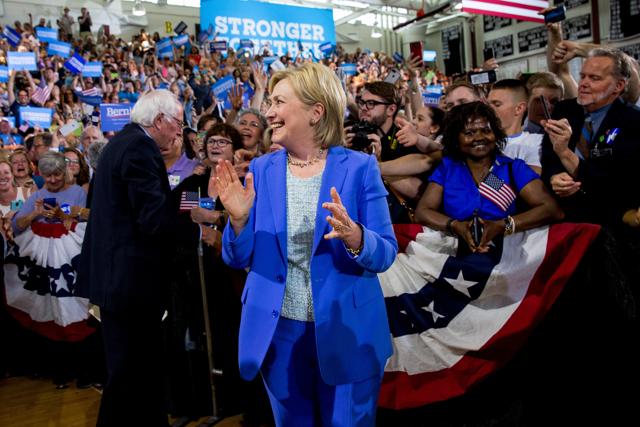 With Clinton smiling and nodding beside him, Sanders listed his reasons for endorsing her — that read much like his own agenda which, in his words, was now adopted by her. (AP)