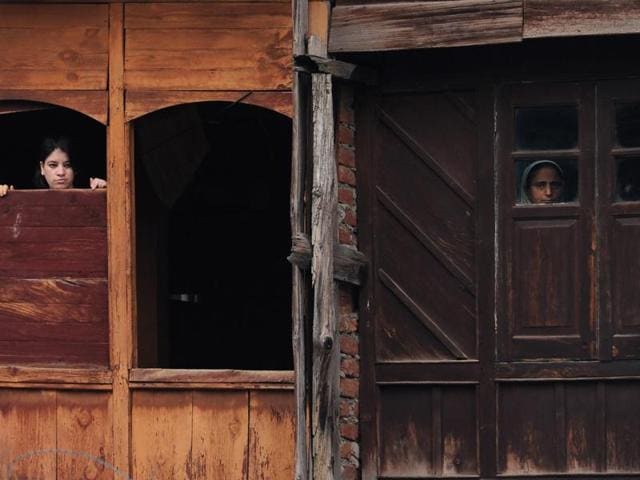 Kashmiris look out of the windows of a house in Srinagar on Wednesday. Police and government officials say that banning mobile and internet services is a ‘violence control measure’. (AFP Photo) Kashmiris look out of the windows of a house in Srinagar on Wednesday. Police and government officials say that banning mobile and internet services is a ‘violence control measure’. (AFP Photo)