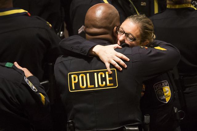 Injured Dallas area rapid transit police officer Misty McBride gets a hug as she arrives for interfaith memorial service. (AP)