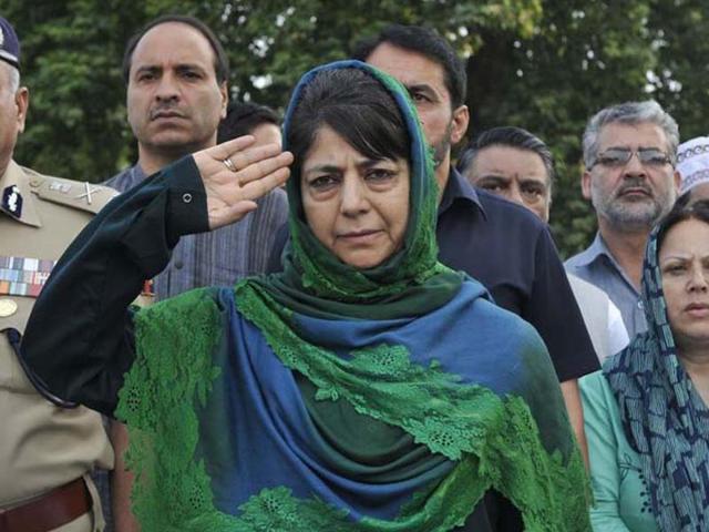 Jammu and Kashmir chief minister Mehbooba Mufti salutes a police guard of honour at the Mazar-e-Shohda (Martyr's Graveyard), during the commemoration of Martyrs' Day in Srinagar on Wednesday.(Waseem Andrabi /HT Photo)