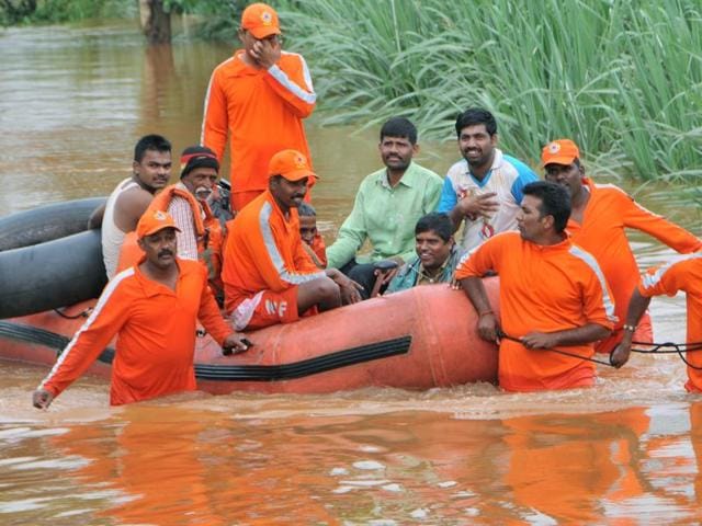 NDRF personnel evacuating stranded people from a flooded village in Kolhapur. (HT PHOTO)
