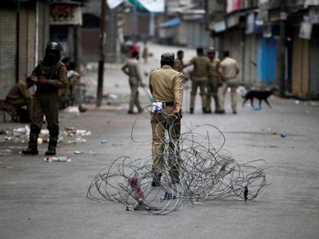 A policeman pulls concertina wire to lay a barricade on a road during a curfew in Srinagar. (Reuters Photo) A policeman pulls concertina wire to lay a barricade on a road during a curfew in Srinagar. (Reuters Photo)