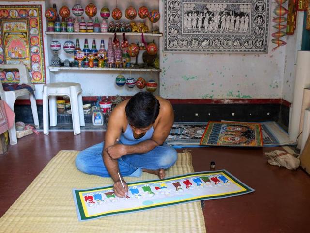 An artist displays a Patachitra scroll in Raghurajpur, Odisha(Getty Images)