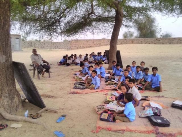 Students study under a tree at a Barmer school.(HT Photo) Students study under a tree at a Barmer school.(HT Photo)