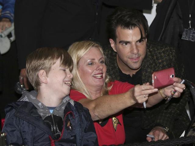 Zachary Quinto, who plays Spock, has a selfie taken with a fan as he walks on the red carpet during the premiere of the film Star Trek Beyond. (AP) 
