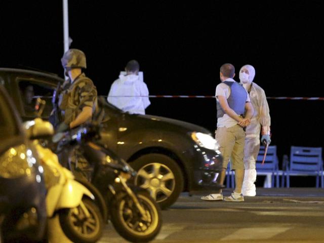 Forensic officers at the scene of an attack after a truck drove on to the sidewalk and plowed through a crowd of revelers who'd gathered to watch the fireworks in the French resort city of Nice. (AP)