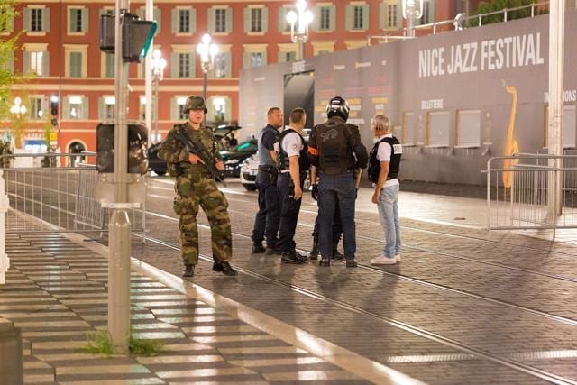 Police officers and a soldier stand by the sealed-off area in Nice. (AP) Police officers and a soldier stand by the sealed-off area in Nice. (AP)