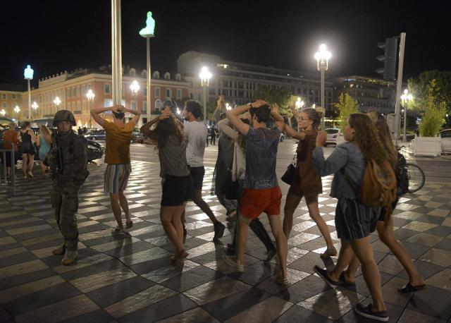 People cross the street with their hands on their heads as a French soldier secures the area. (REUTERS) People cross the street with their hands on their heads as a French soldier secures the area. (REUTERS)