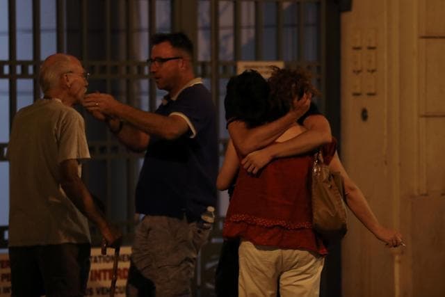 People react in the French Riviera town of Nice on July 15, 2016, after the truck attack. (AFP)