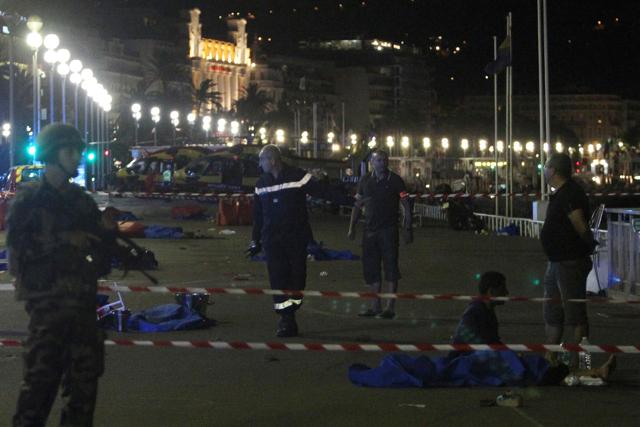 Soldiers, police officers and firefighters walk near dead bodies covered with a blue sheets on the Promenade des Anglais seafront in the French Riviera town of Nice on July 15, 2016, after a van drove into a crowd watching a fireworks display. (AFP) Soldiers, police officers and firefighters walk near dead bodies covered with a blue sheets on the Promenade des Anglais seafront in the French Riviera town of Nice on July 15, 2016, after a van drove into a crowd watching a fireworks display. (AFP)