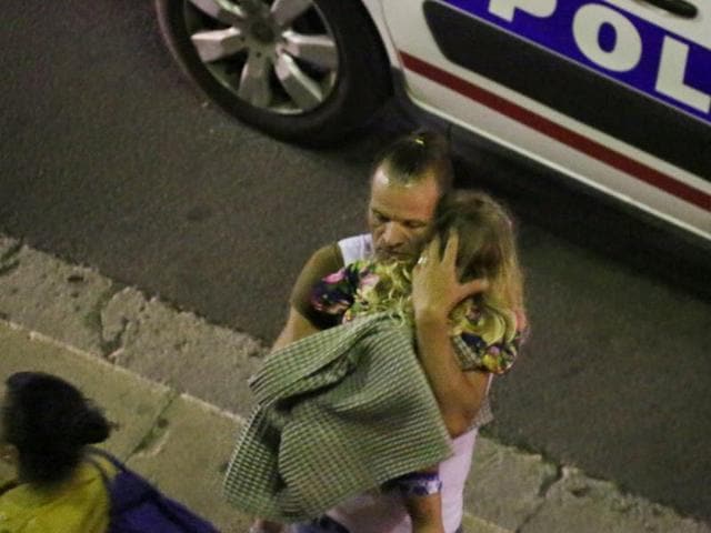 A man comforts a child after the truck attack. (AP) A man comforts a child after the truck attack. (AP)