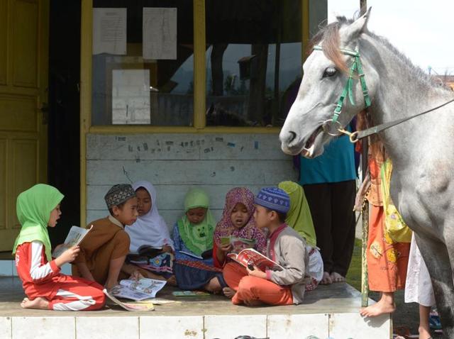 It is book time for these children.  (AFP) 