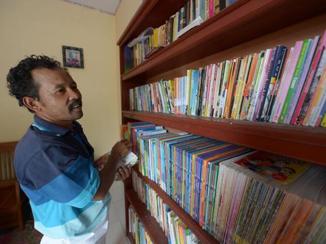Ridwan selects books for villagers he will visit. (AFP) 