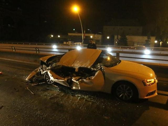 A man stands near a car which was crushed by an armoured vehicle in Ankara. (Reuters) 