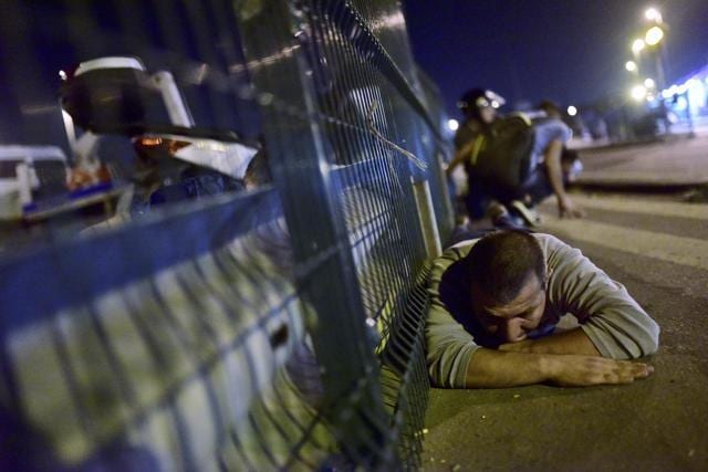 People take cover near a bridge during an attempted coup in Istanbul. (REUTERS) People take cover near a bridge during an attempted coup in Istanbul. (REUTERS)