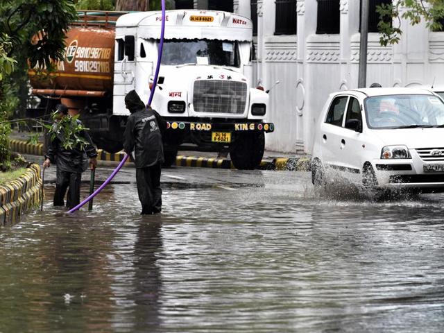 NDMC workers try to free clogged up drains near Jantar Mantar after heavy over-night rains. (Mohd Zakir/HT Photo) NDMC workers try to free clogged up drains near Jantar Mantar after heavy over-night rains. (Mohd Zakir/HT Photo)
